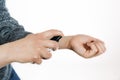 Closeup of hands of a person testing the smell of perfume on white background