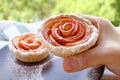 Hands picking a mouthwatering rose-shaped apple mini pie Royalty Free Stock Photo
