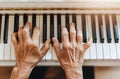 Closeup of hands playing the piano, white background, natural light, soft tones, indoor environ