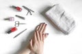Closeup of hands with polished nails and manicure instruments, bottles of nail polish. caucasian woman receiving french Royalty Free Stock Photo