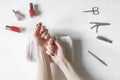 Closeup of hands with polished nails and manicure instruments, bottles of nail polish. caucasian woman receiving french Royalty Free Stock Photo