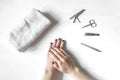 Closeup of hands with polished nails and manicure instruments. Young caucasian woman receiving homemade french manicure at nail Royalty Free Stock Photo