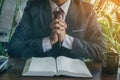 Closeup of hands praying on bible