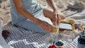 Closeup hands preparing picnic in sunlight. Relaxed girl pour water into glass