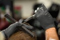 Closeup of hands of barber in protective gloves cutting hair