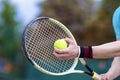 Closeup of Hands of Professional Male tennis Player Holding Raquet and Tennis Ball in Contact.