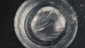 Closeup hands put ice cube into mineral water glass. Preparing drinks concept Royalty Free Stock Photo