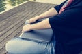 Closeup of hands resting on closed laptop.