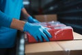 Closeup hands in rubber gloves handle cardboard boxes for fast online shopping delivery