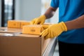 Closeup hands in rubber gloves handle cardboard boxes for fast online shopping delivery
