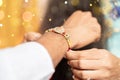 Closeup of hands, sister tying rakhi, Raksha bandhan to brother`s wrist during festival or ceremony - Rakshabandhan