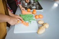 Closeup of hands slicing carrots on chopping board