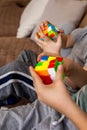 Closeup hands smart babies assembling Rubik's cube 3x3 enjoying early development game at home