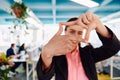 Closeup of hands, Smiling Business Woman Making Frame Gesture with at modern bright coworking open space startup office Royalty Free Stock Photo