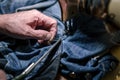 Closeup hands of Tailor man working on old sewing machine. jeans cloth fabric textile in shop, Tailoring, close up Royalty Free Stock Photo