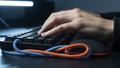 Closeup of hands typing on a computer keyboard with colorful cables Royalty Free Stock Photo
