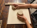 Closeup of hands of woman ceramist working and finishing ceramic pot with clay on wooden table in workshop Royalty Free Stock Photo