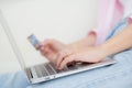 Closeup hands of woman sitting on sofa using laptop computer online shopping with credit card. Royalty Free Stock Photo