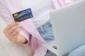 Closeup hands of woman sitting on sofa using laptop computer online shopping with credit card. Royalty Free Stock Photo