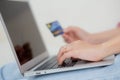 Closeup hands of woman sitting on sofa using laptop computer online shopping with credit card. Royalty Free Stock Photo