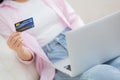 Closeup hands of woman sitting on sofa using laptop computer online shopping with credit card. Royalty Free Stock Photo