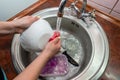 Close up hands of woman washing dishes in kitchen. Cleaning chores Royalty Free Stock Photo