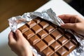 closeup of hands wrapping a chocolate bar in foil Royalty Free Stock Photo