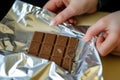 closeup of hands wrapping a chocolate bar in foil Royalty Free Stock Photo