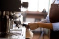 Closeup hands of young asian woman holding coffee grinder powder while mashed for preparing making coffee in cafe. Royalty Free Stock Photo