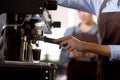 Closeup hands of young asian woman holding coffee grinder powder while mashed for preparing making coffee. Royalty Free Stock Photo