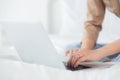 Closeup hands young asian woman sitting on bed using laptop computer working from home in the bedroom. Royalty Free Stock Photo
