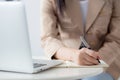 Closeup hands young asian woman writing on notebook for planning working and using laptop computer on desk. Royalty Free Stock Photo