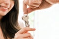 Closeup hands of young happy Asian couple showing, holding keys to the camera inside their new home. Moving, relocating. Royalty Free Stock Photo