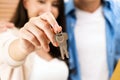 Closeup hands of young happy Asian couple showing, holding keys to the camera inside their new home. Moving, relocating. Royalty Free Stock Photo