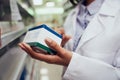 Closeup of hands of young woman holding medicine box reading name in chemist Royalty Free Stock Photo