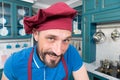 Closeup of Handsome chef in hat with smile to you. Man in apron at kitchen. Portrait of happy chef