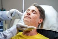 Closeup handsome man having color light therapy to stimulate facial skin Royalty Free Stock Photo