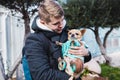 Closeup of handsome young man holding a cute chihuahua dog outdoor Royalty Free Stock Photo