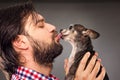Closeup of handsome young man holding a cute chihuahua dog Royalty Free Stock Photo