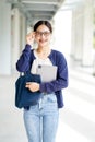 Closeup happiness cheerful Asian young female student in casual cloth holding a laptop with touch eyeglas