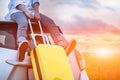 Closeup of happy Asian woman on top of car with luggage bag. Girl sitting on roof and looking sunset before evening. People Royalty Free Stock Photo