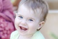 Closeup of happy baby smiling with her first teeth