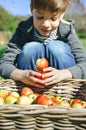 Happy kid playing with apples over wicker basket Royalty Free Stock Photo