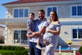 Happy family standing in front of new modern house Royalty Free Stock Photo