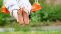 Closeup of happy kid sitting and swinging, sunny summer day, countryside background. Child feet barefoot. Copy space Royalty Free Stock Photo