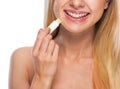 Closeup on happy teenage girl applying hygienic lipstick Royalty Free Stock Photo