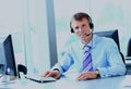 Happy young man working at callcenter, using headset. Royalty Free Stock Photo