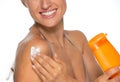 Closeup on happy woman applying sun screen bottle Royalty Free Stock Photo