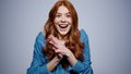 Positive girl making hand gestures in studio. Woman getting good news indoors Royalty Free Stock Photo