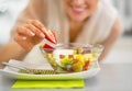 Closeup on happy woman serving fresh fruit salad Royalty Free Stock Photo